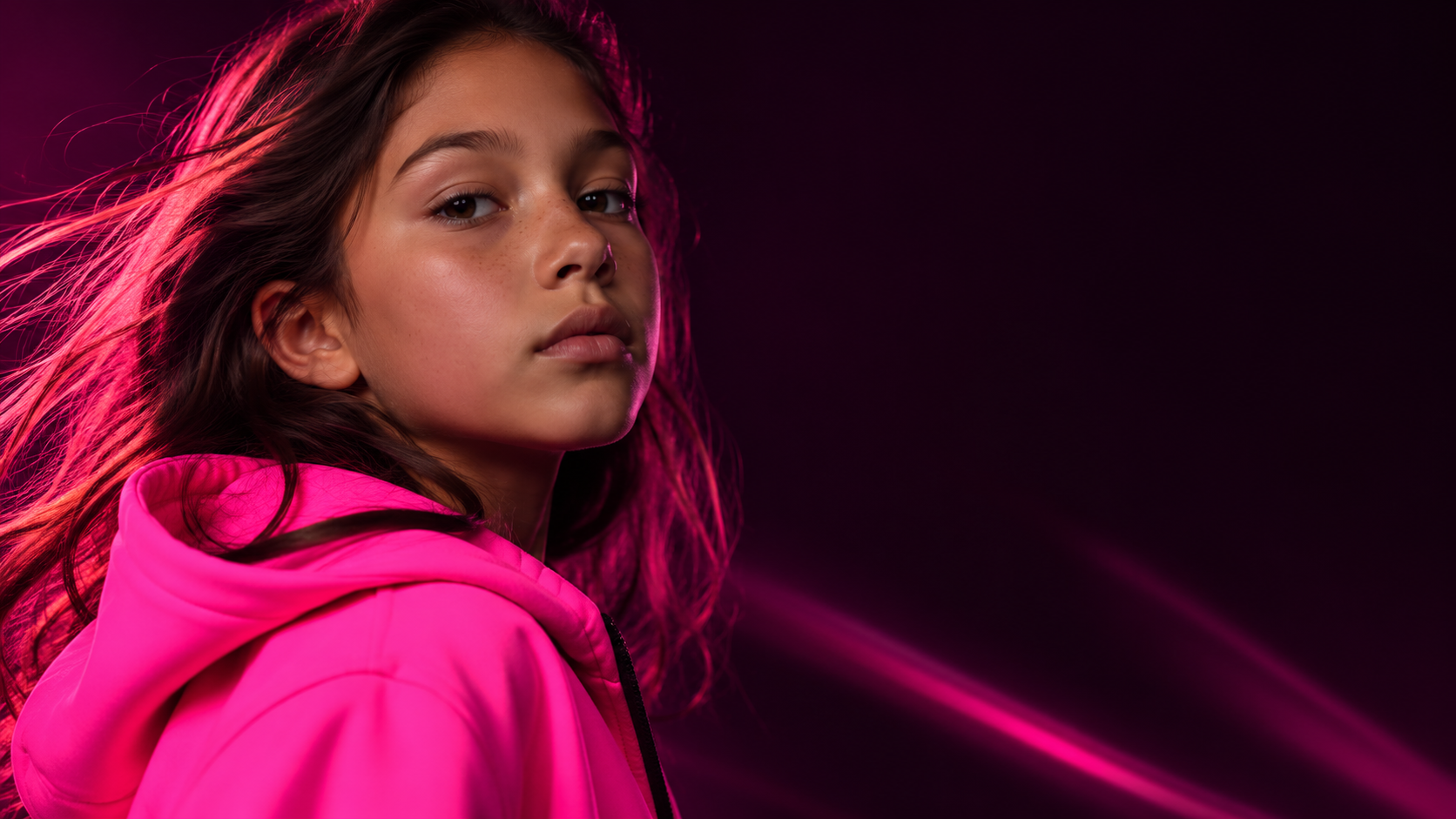 A girl in a neon pink hoodie lit by pink light