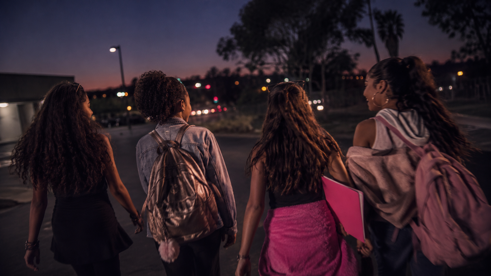 Four girls walking together at night